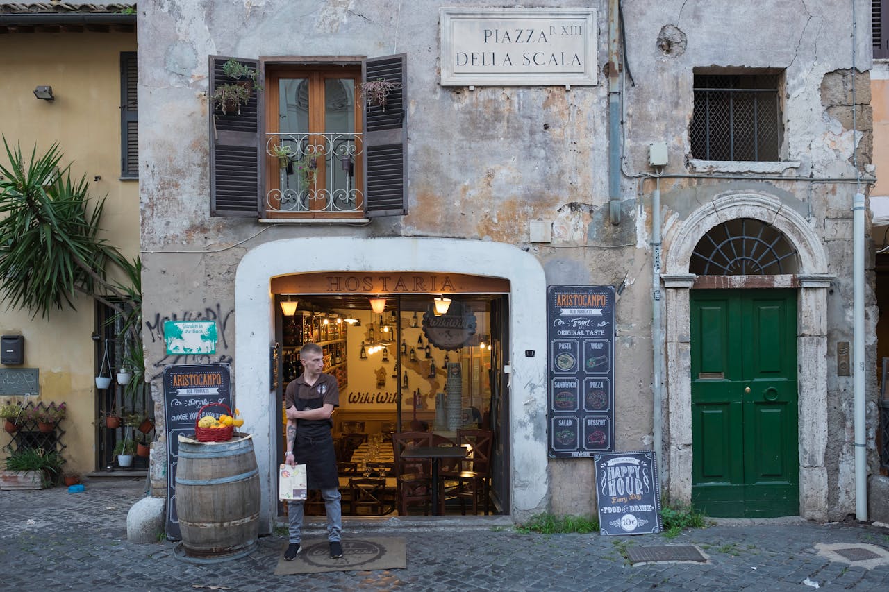 Photo by Vito Giaccari: https://www.pexels.com/photo/a-waiter-standing-outside-the-restaurant-while-holding-a-menu-8220057/